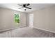 Bedroom with ceiling fan and a view of backyard trees through a window at 810 Williams St, Burlington, NC 27217