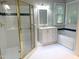 Bright bathroom featuring a shower with gold trim, vanity, soaking tub and white tile at 8100 Laurel Mountain Rd, Raleigh, NC 27613