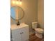 Bathroom features a modern vanity with a round mirror and updated fixtures at 8100 Laurel Mountain Rd, Raleigh, NC 27613