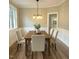 Dining room featuring wainscotting, wood floors, and a modern chandelier at 8100 Laurel Mountain Rd, Raleigh, NC 27613