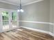 Dining room features chandelier and French doors leading to outdoor deck at 8100 Laurel Mountain Rd, Raleigh, NC 27613