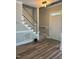 Inviting foyer with wood-look flooring, staircase with wood banister, and natural light streaming through the front door at 8100 Laurel Mountain Rd, Raleigh, NC 27613