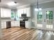 Modern kitchen featuring stainless steel appliances, white cabinets, and wood-look floors, with access to an outdoor deck at 8100 Laurel Mountain Rd, Raleigh, NC 27613