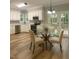 Eat-in kitchen features stainless steel appliances, white cabinets, and glass table near patio doors at 8100 Laurel Mountain Rd, Raleigh, NC 27613