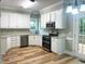 Updated kitchen with white cabinets, granite countertops, and stainless steel appliances at 8100 Laurel Mountain Rd, Raleigh, NC 27613