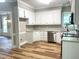 Bright kitchen features white cabinetry, stainless steel appliances, and wood-look floors at 8100 Laurel Mountain Rd, Raleigh, NC 27613