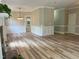 Open living room with brick fireplace, attractive light wood flooring, and decorative trim at 8100 Laurel Mountain Rd, Raleigh, NC 27613