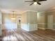 Open-concept living room with elegant wainscoting, contemporary lighting, and wood-look floors, flowing to an outdoor area at 8100 Laurel Mountain Rd, Raleigh, NC 27613