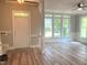 Bright and airy living room featuring large windows, wood-look floors, and classic moldings, creating an inviting space at 8100 Laurel Mountain Rd, Raleigh, NC 27613