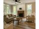 Inviting living room with a brick fireplace, large windows, and stylish wood flooring at 8100 Laurel Mountain Rd, Raleigh, NC 27613