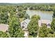 Aerial image of a stately residence nestled among trees with lake views, offering privacy and scenic beauty at 81002 Alexander, Chapel Hill, NC 27517
