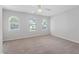 Neutral bedroom featuring a ceiling fan and many windows for ample natural light at 8422 Central Dr, Raleigh, NC 27613