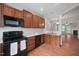 Kitchen featuring wood cabinets, black appliances, and a sink at 8422 Central Dr, Raleigh, NC 27613