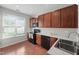 Kitchen featuring wood cabinets, black appliances, and a bright window at 8422 Central Dr, Raleigh, NC 27613