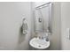Compact powder room with a pedestal sink, a decorative mirror, and neutral color scheme at 8885 Commons Townes Dr, Raleigh, NC 27616