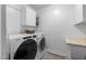 Bright laundry room featuring side by side washer and dryer and overhead cabinetry at 914 Cindy St, Cary, NC 27511