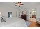 Bright bedroom with hardwood floors, a ceiling fan, and view into bathroom at 997 Windy Rd, Apex, NC 27502