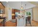 Open kitchen with granite countertops, an island with seating, stainless steel appliances, and hardwood floors at 997 Windy Rd, Apex, NC 27502