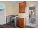 Laundry room includes washer, dryer, wooden cabinets, and access to screened deck at 997 Windy Rd, Apex, NC 27502