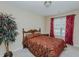 Bedroom with a large plant and window with red curtains at 101 Kingston Ln, Graham, NC 27253