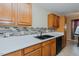 Galley kitchen with stainless steel sink, modern backsplash, and wooden cabinets at 101 Kingston Ln, Graham, NC 27253