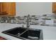 Close-up of the kitchen sink, featuring a modern faucet and stylish backsplash at 101 Kingston Ln, Graham, NC 27253