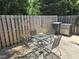 Relaxing patio area with charming outdoor furniture, a grill, and a privacy fence with string lights at 101 Kingston Ln, Graham, NC 27253