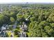 Lush, green trees surround the property in this neighborhood near a main road in an aerial view at 1021 Manchester Dr, Raleigh, NC 27609