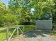 Picturesque backyard with mature trees, a shed, and a gate for access at 1022 Carolina Ave, Durham, NC 27705