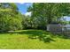 Private backyard featuring a large green lawn, mature trees, wooden fence and an outdoor shed at 1022 Carolina Ave, Durham, NC 27705