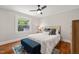 Comfortable bedroom featuring natural light from a window, complemented by a ceiling fan and wood floors at 1022 Carolina Ave, Durham, NC 27705