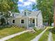 Charming grey home featuring a well-manicured lawn, dormers, and sidewalk entrance at 1022 Carolina Ave, Durham, NC 27705