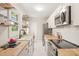Modern kitchen with white cabinets, butcher block countertops, stainless steel appliances and floating shelves at 1022 Carolina Ave, Durham, NC 27705