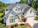 A stunning aerial view of a two-story home with lush landscaping, an attached garage, and a classic architectural style at 103 Equestrian Ct, Cary, NC 27513
