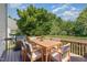 Wooden back deck features a gas grill, dining table and six chairs with cushions surrounded by foliage at 103 Equestrian Ct, Cary, NC 27513