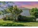 Back yard at sunset features a lush green lawn, mature trees, shrubs, and the rear of the house at 103 Equestrian Ct, Cary, NC 27513