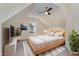 Cozy bedroom features a ceiling fan, TV, plants, a wood bed frame, bedside table and window at 103 Equestrian Ct, Cary, NC 27513