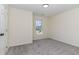 This empty bedroom has neutral carpet and walls, a window for natural light, and a flush mount ceiling light at 103 Equestrian Ct, Cary, NC 27513