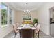 This dining room is brightly lit with large windows and features a white table with seating for six at 103 Equestrian Ct, Cary, NC 27513