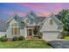 Charming two-story traditional home featuring a manicured lawn, attached garage, and welcoming entrance with brick steps at 103 Equestrian Ct, Cary, NC 27513