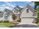 Charming two-story traditional home featuring a manicured lawn, attached garage, and welcoming entrance with brick steps at 103 Equestrian Ct, Cary, NC 27513