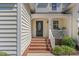 Inviting front porch featuring classic columns, brick steps, and a beautifully designed front door at 103 Equestrian Ct, Cary, NC 27513