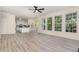 Bright, open living room with large windows offering natural light and a view of the connected kitchen and outdoor areas at 103 Equestrian Ct, Cary, NC 27513