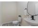 Modern powder room featuring a sleek pedestal sink, round mirror, and a contemporary toilet for guests at 103 Equestrian Ct, Cary, NC 27513