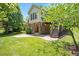 Well-manicured backyard featuring lush green grass, a patio, and exterior stairs leading up to a deck at 107 Sonoma Valley Dr, Cary, NC 27518
