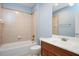 Neat bathroom with tiled walls, framed mirror, single sink vanity, and soaking tub with shower at 107 Sonoma Valley Dr, Cary, NC 27518