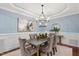 Dining room features a modern chandelier, wainscoting, and a stylish table set for six at 107 Sonoma Valley Dr, Cary, NC 27518