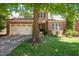 Brick and stone home with a manicured lawn, attached garage, and mature shade trees in the front yard at 107 Sonoma Valley Dr, Cary, NC 27518