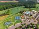 Aerial view of the golf course, tennis courts, and community pool surrounded by lush trees at 108 Ribbon Walk Ln, Holly Springs, NC 27540