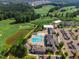 Aerial view of large community pool with clubhouse and meticulously maintained golf course at 108 Ribbon Walk Ln, Holly Springs, NC 27540